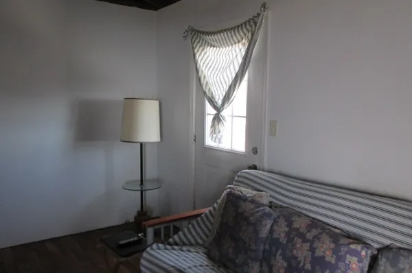 a view of bedroom with wooden floor and window