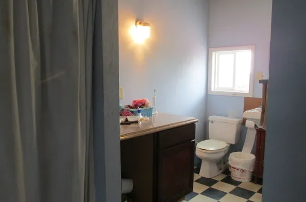a bathroom with a sink toilet and window