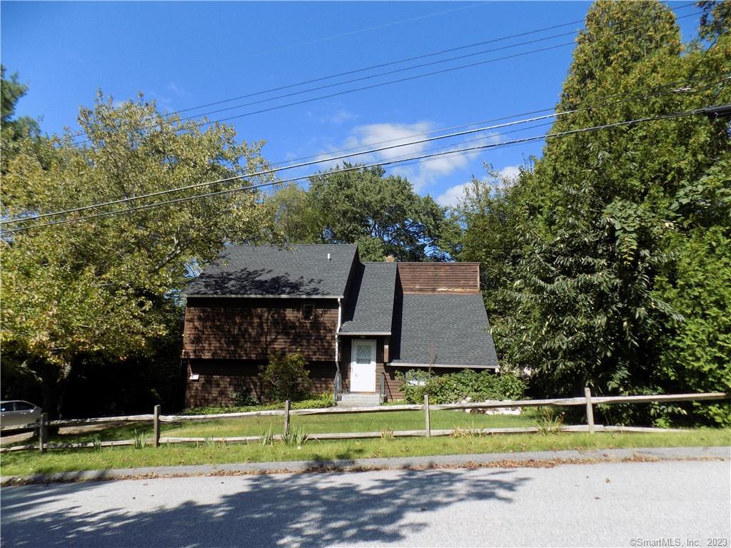 a front view of a house with a yard and trees
