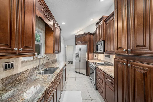 a kitchen with stainless steel appliances granite countertop a sink stove and refrigerator