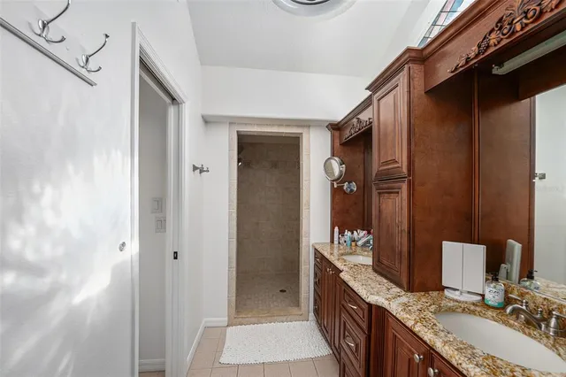 a bathroom with a granite countertop double vanity sink and a mirror