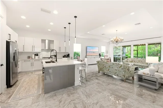 a large white kitchen with lots of counter space wooden floor and appliances