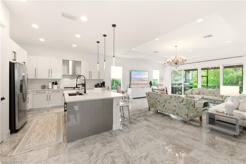 a large white kitchen with lots of counter space wooden floor and appliances