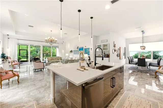 a kitchen with a stove a sink and living room view