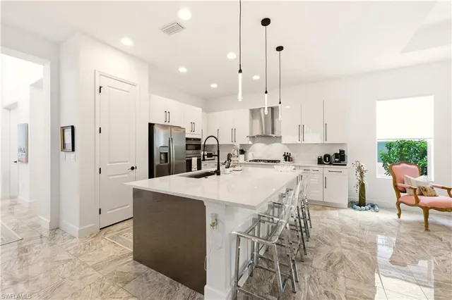 a large kitchen with kitchen island a table and chairs in it
