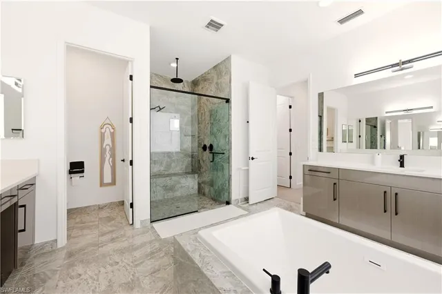 a spacious bathroom with a shower sink and a mirror
