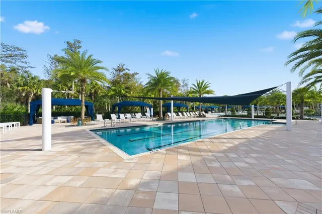 a view of swimming pool with table and chairs a barbeque with potted plants