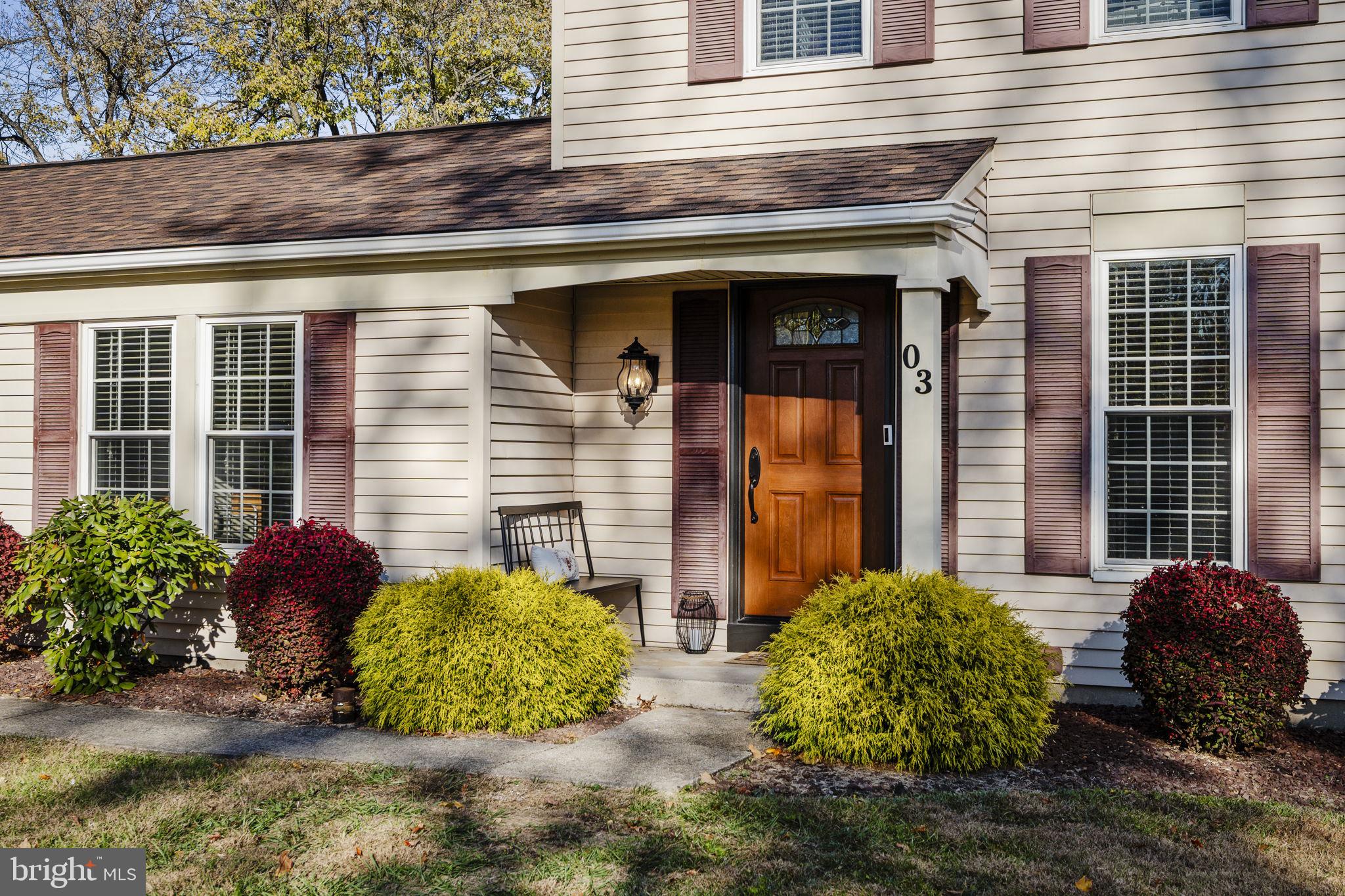 a view of a house with potted plants and a bench