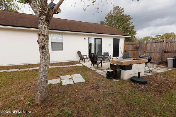 a view of a patio with table and chairs with wooden floor and fence