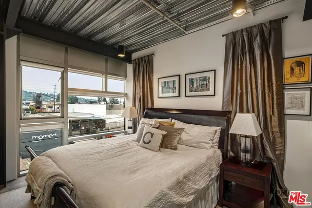 a bedroom with a bed next to a window