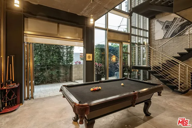 a room with pool table and windows