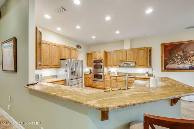 a large kitchen with stainless steel appliances lots of counter space and breakfast area