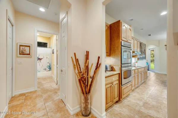 a view of a kitchen with kitchen island stainless steel appliances microwave stove refrigerator and cabinets