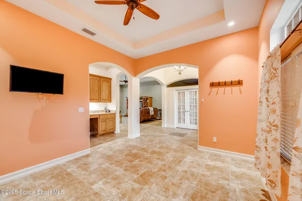 a view of a livingroom with a fireplace a ceiling fan and front door