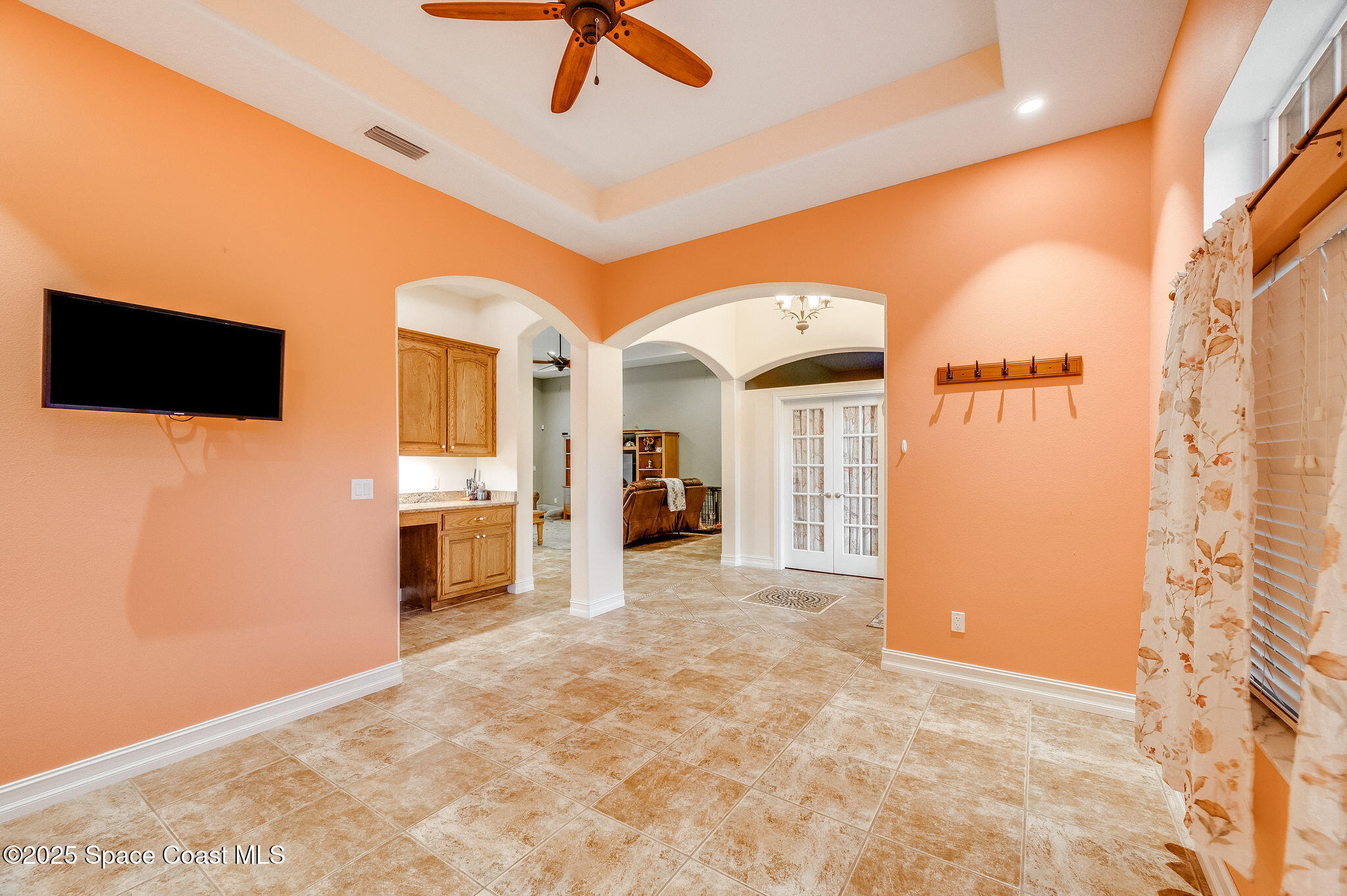 2800 Parrish Road Titusville, FL 32796 - Photo 9 of 45 a view of a livingroom with a fireplace a ceiling fan and front door