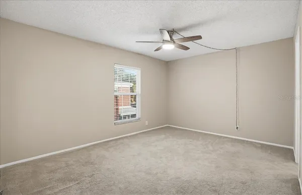 a view of an empty room and a ceiling fan