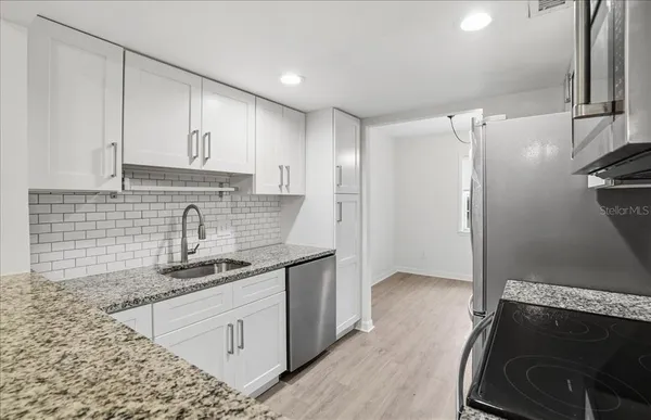 a kitchen with granite countertop a stove and a microwave