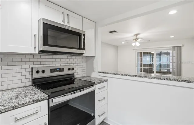 a kitchen with stainless steel appliances granite countertop a sink and cabinets