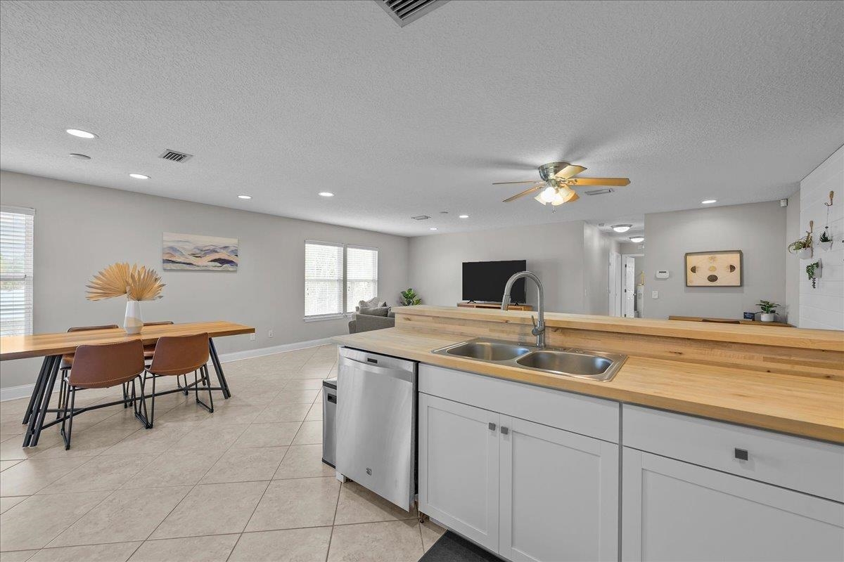 736-8 Kings Estate Road St. Augustine, FL 32086 - Photo 39 of 40 Kitchen with stainless steel dishwasher, white cabinetry, open floor plan, light tile patterned floors, and ceiling fan