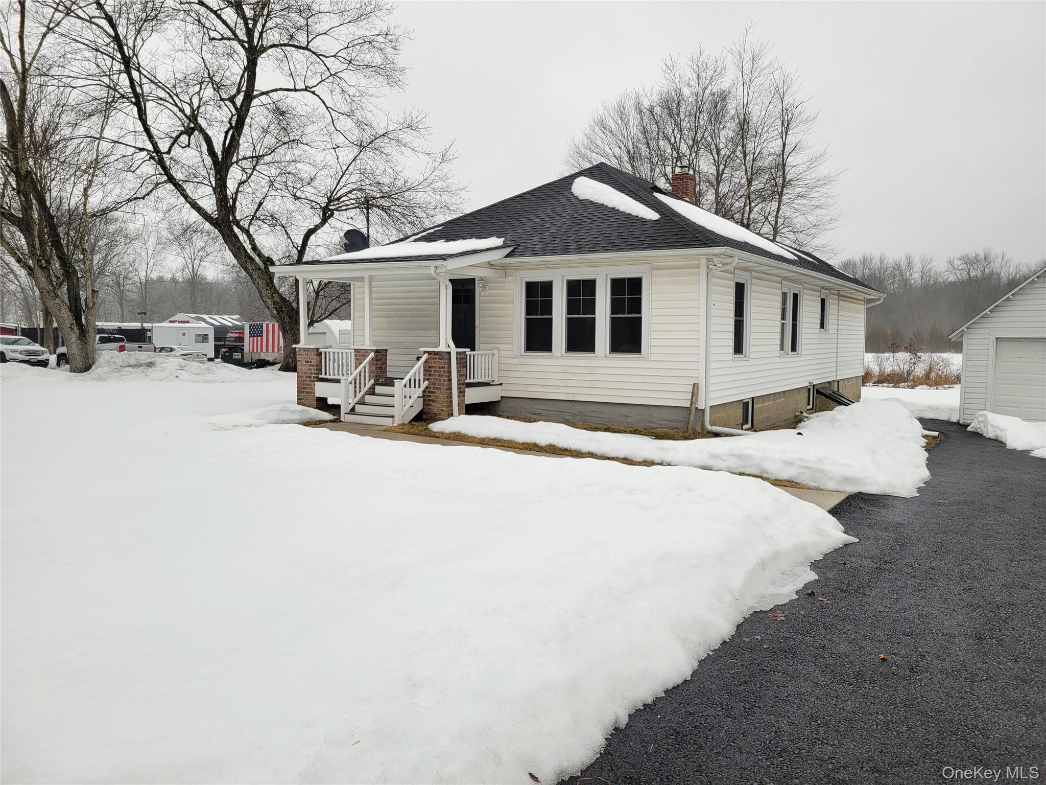a front view of a house with a yard covered in snow