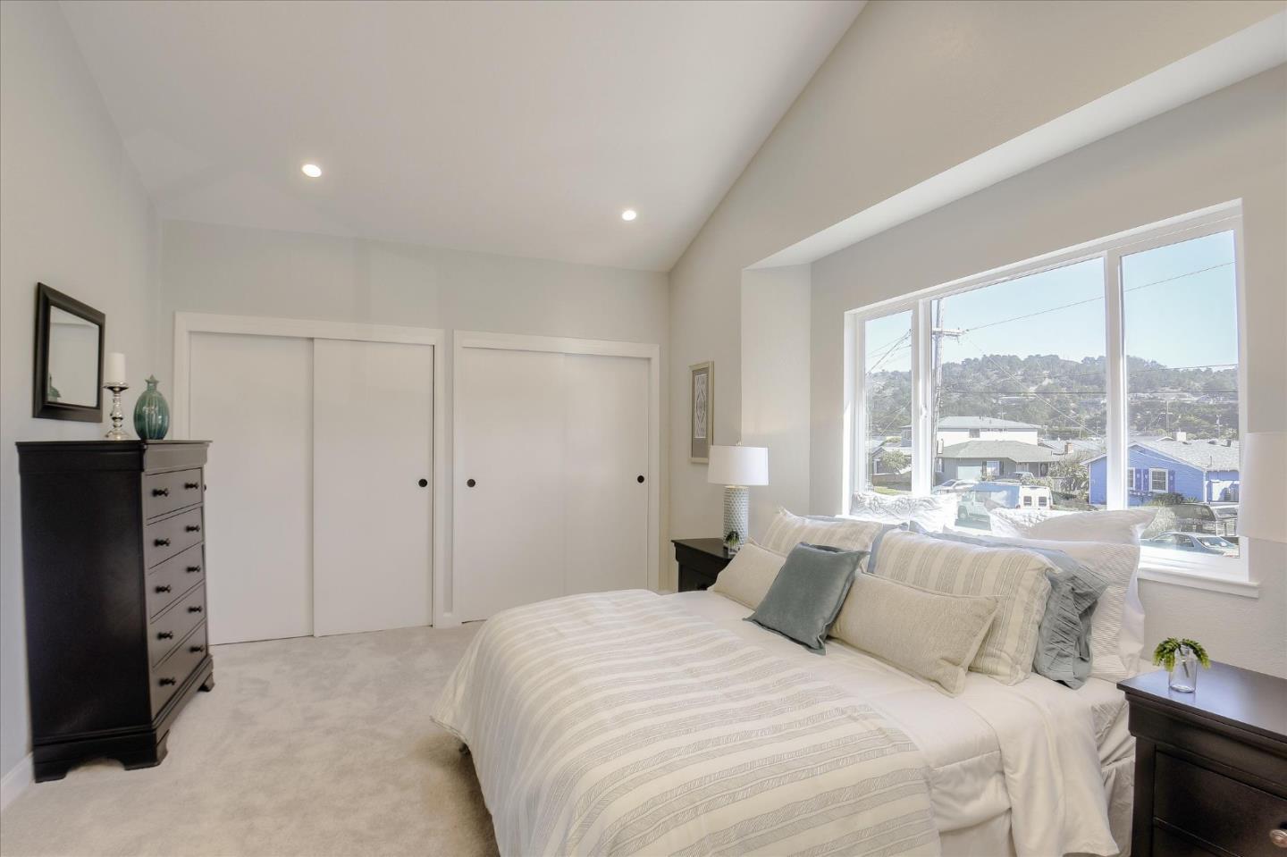 504 Arguello Boulevard Pacifica, CA 94044 - Photo 20 of 42 a bedroom with a large bed and a large window