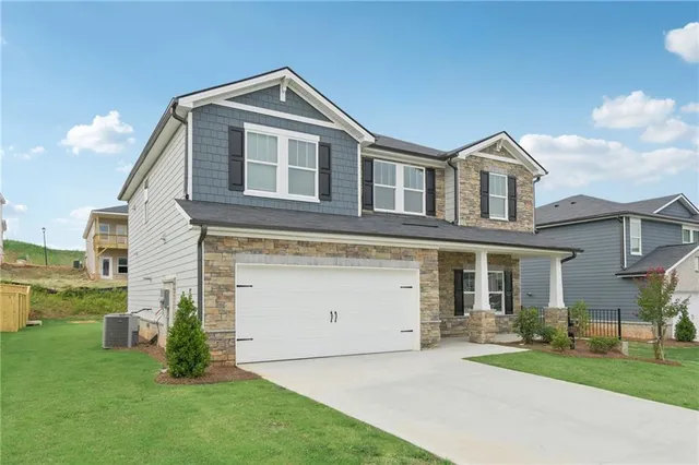 a front view of a house with a garden and yard