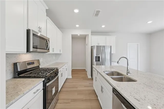 a kitchen with stainless steel appliances a refrigerator sink and cabinets