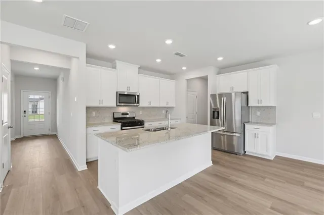 a large kitchen with stainless steel appliances and a refrigerator