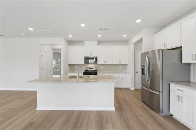 a kitchen with stainless steel appliances granite countertop a sink stove and refrigerator