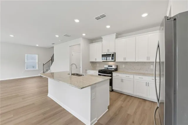 a large kitchen with stainless steel appliances granite countertop a stove and a sink