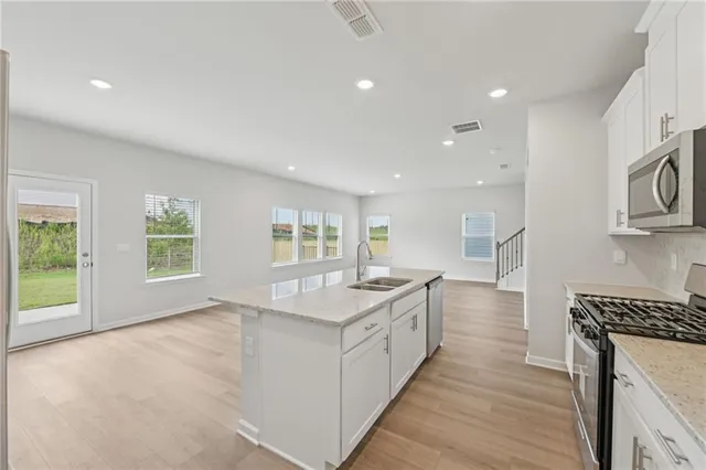 a kitchen with granite countertop white cabinets and appliances