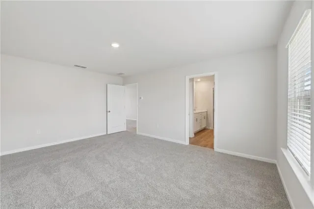 a spacious bathroom with a granite countertop sink a mirror and a shower