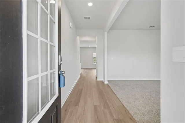 a view of a hallway with wooden floor