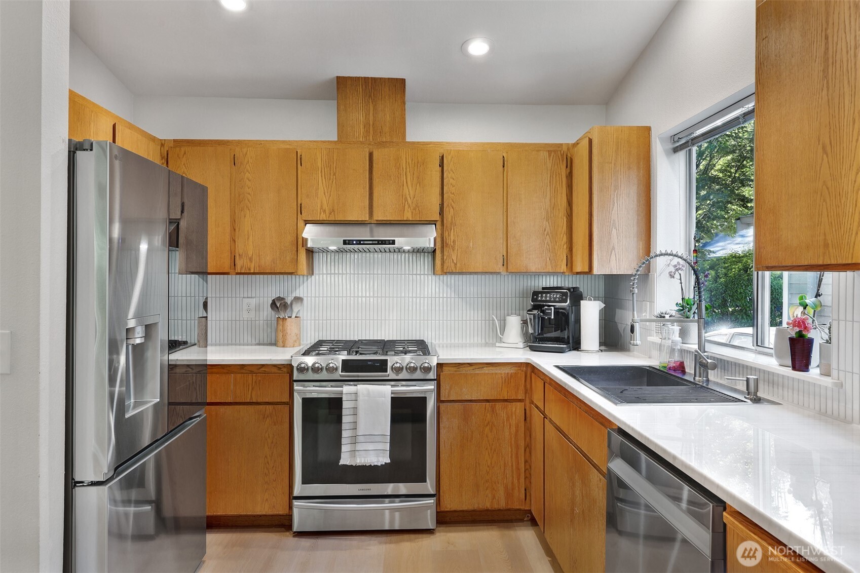 5126 South Garden Loop Road, Unit 11 Seattle, WA 98118 - Photo 11 of 36 a kitchen with stainless steel appliances granite countertop a sink stove and refrigerator