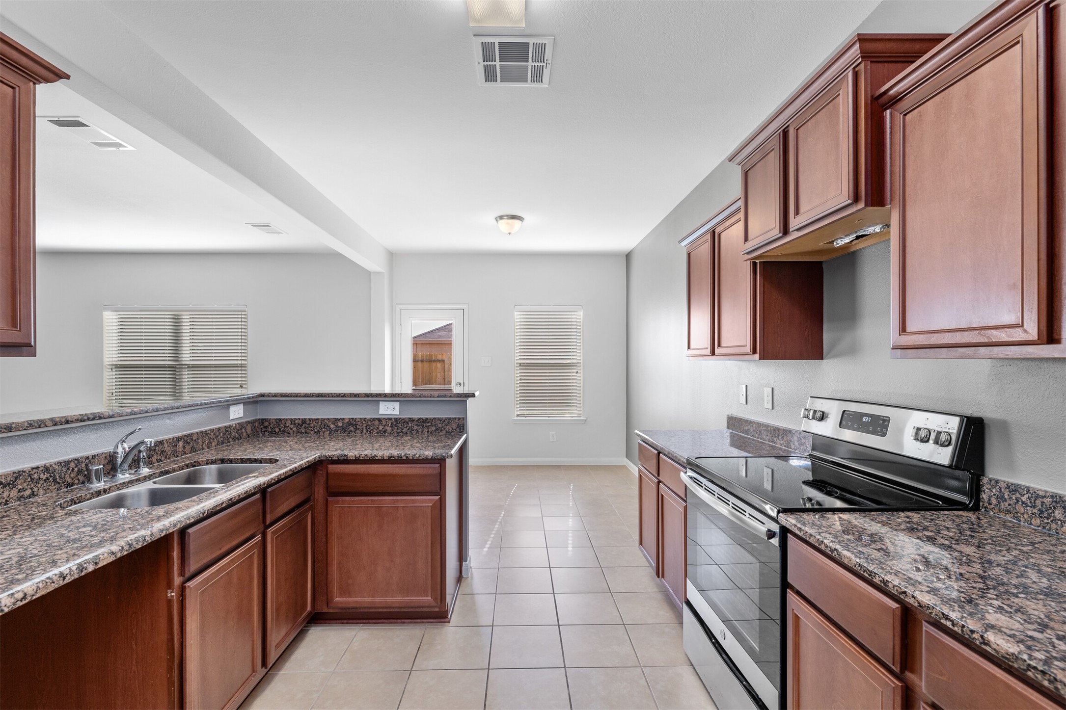 9715 Blue Sapphire Lane Rosharon, TX 77583 - Photo 9 of 30 Kitchen has granite countertops, wood cabinets, stainless steel range/microwave/dishwasher/fridge.