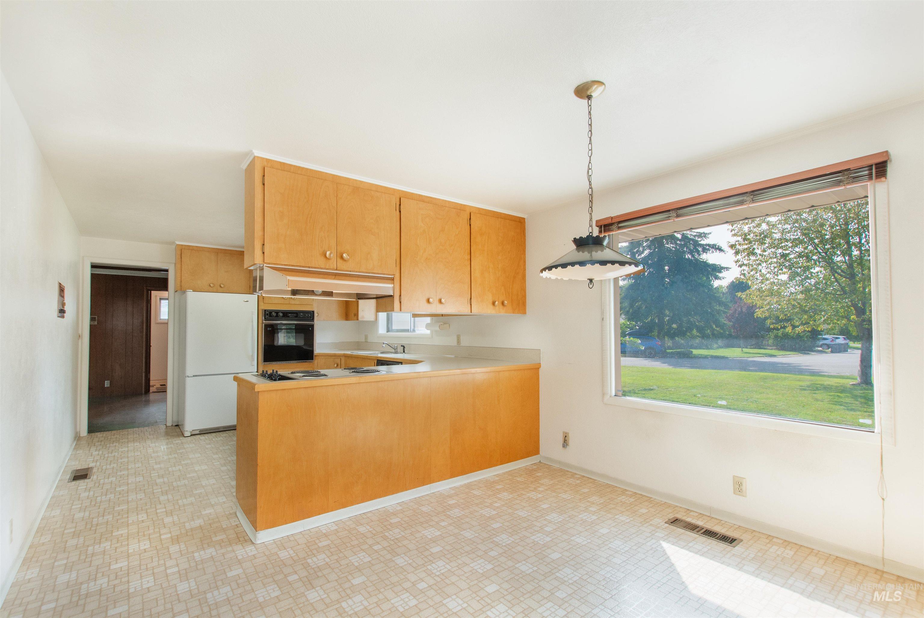 2716 North Redway Road Boise, ID 83704 - Photo 14 of 36 Kitchen featuring wood-finish cabinetry, built-in wall oven, and a large window