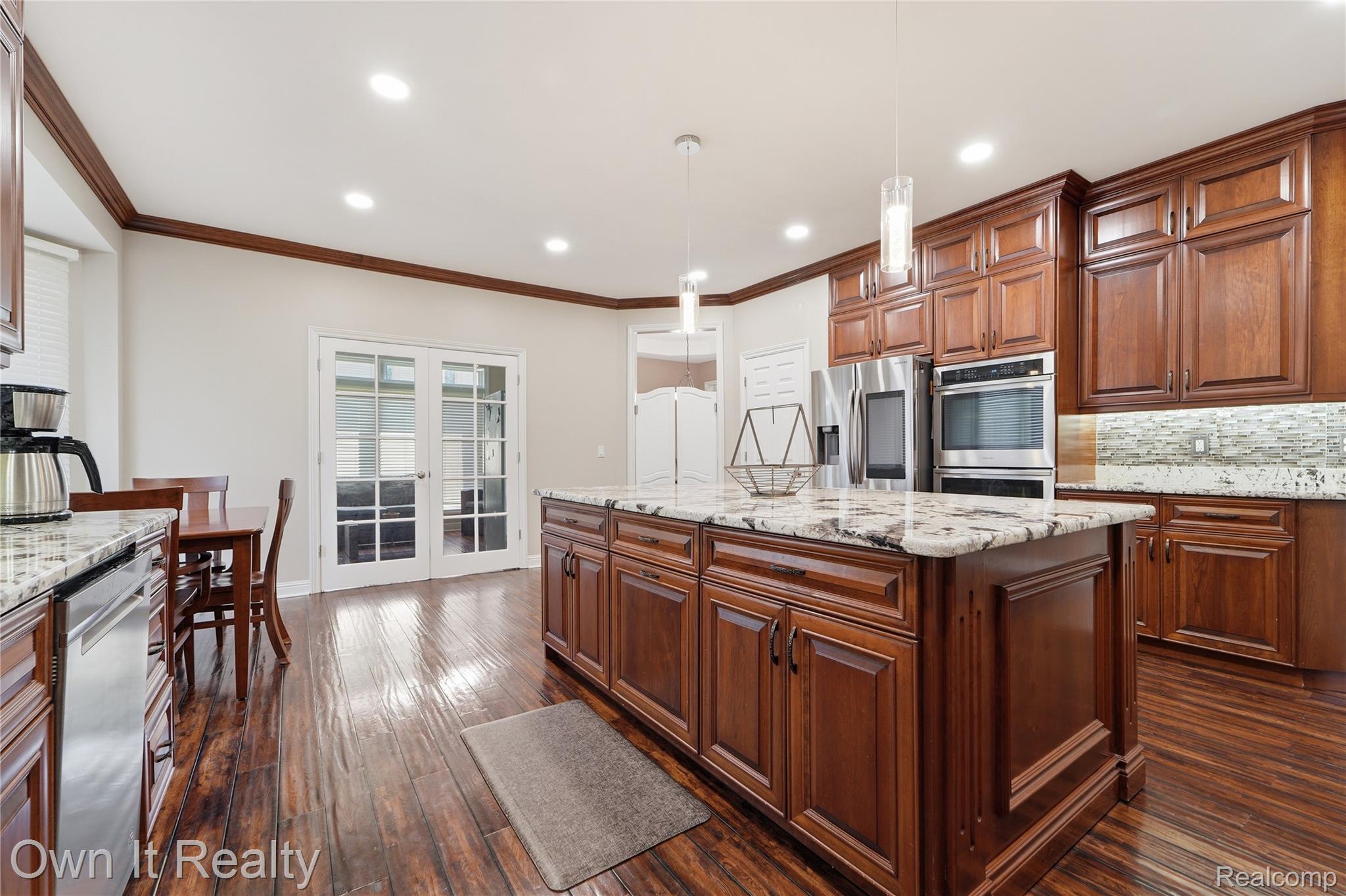 48280 Gladstone Road Canton, MI 48188 - Photo 18 of 59 Kitchen featuring a central island with a granite countertop, extensive wood-finish cabinetry, stainless steel appliances, recessed lighting, and wood-finish flooring