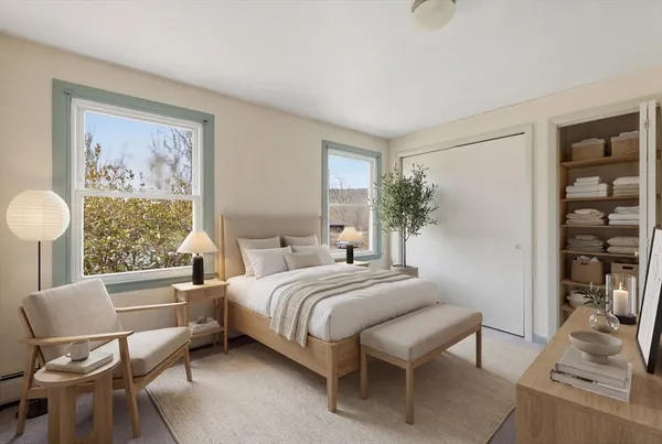 a bedroom with a bed and a chair with the wooden floor