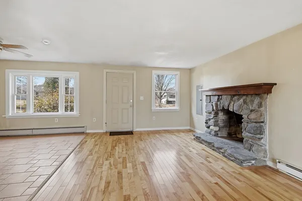 wooden floor fireplace and windows in an empty room