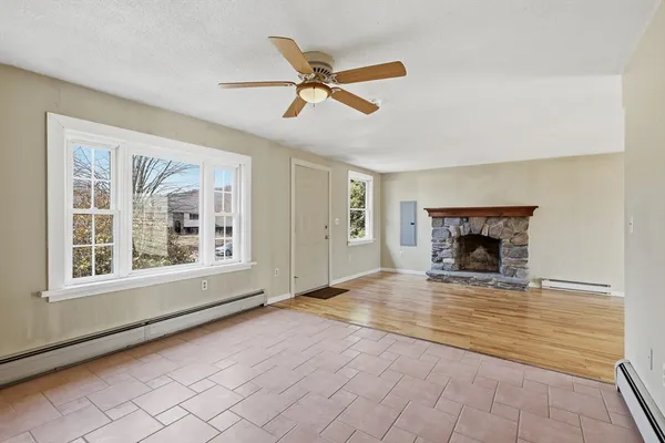 a view of an empty room with a fireplace and a window
