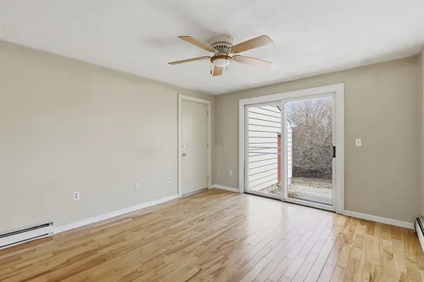 a view of a livingroom with wooden floor and a ceiling fan