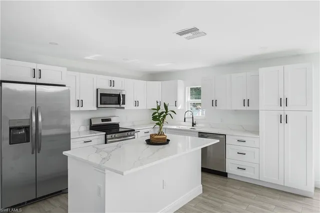 a kitchen with white cabinets and stainless steel appliances