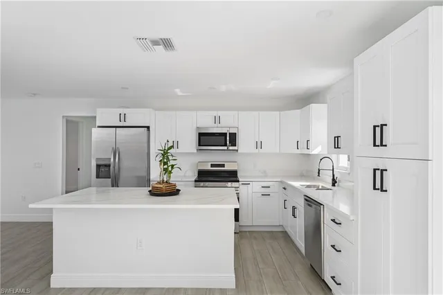 a kitchen with stainless steel appliances a sink a stove a microwave and cabinets