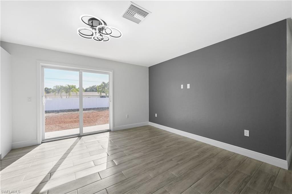4448 18th Avenue Southwest Naples, FL 34116 - Photo 15 of 40 an empty room with wooden floor and windows