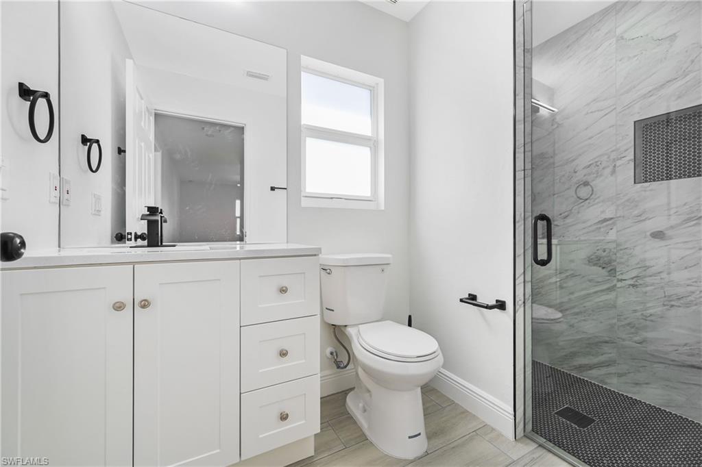 4448 18th Avenue Southwest Naples, FL 34116 - Photo 19 of 40 a bathroom with a toilet sink and a mirror