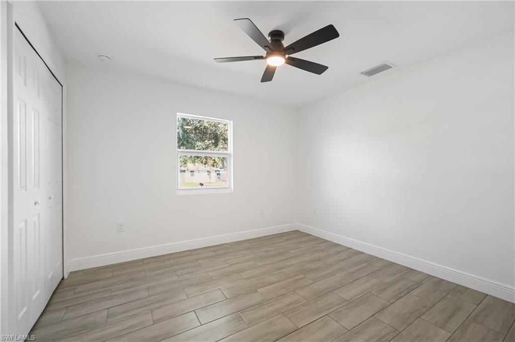 4448 18th Avenue Southwest Naples, FL 34116 - Photo 25 of 40 Unfurnished bedroom with wood finish floors, a closet, and a ceiling fan