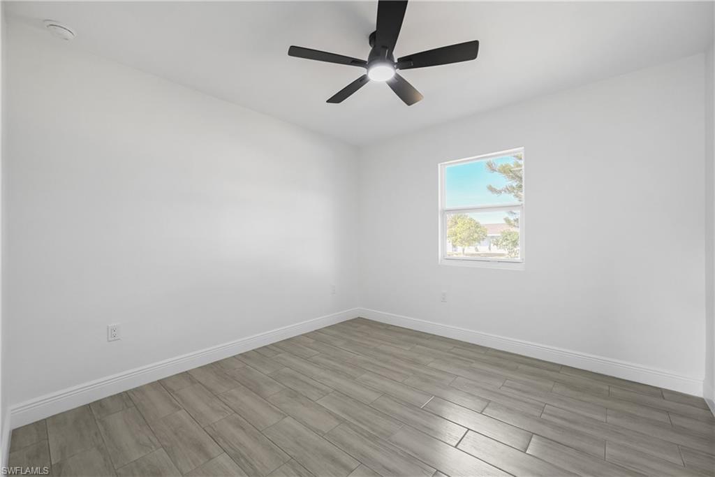4448 18th Avenue Southwest Naples, FL 34116 - Photo 26 of 40 an empty room with wooden floor and ceiling fan
