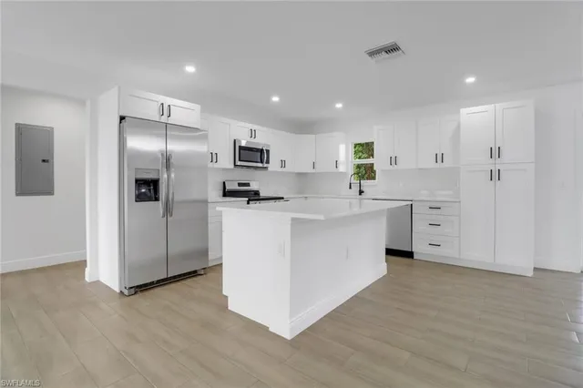a kitchen with white cabinets and stainless steel appliances