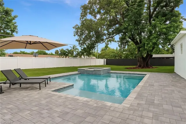 a swimming pool with outdoor seating and yard