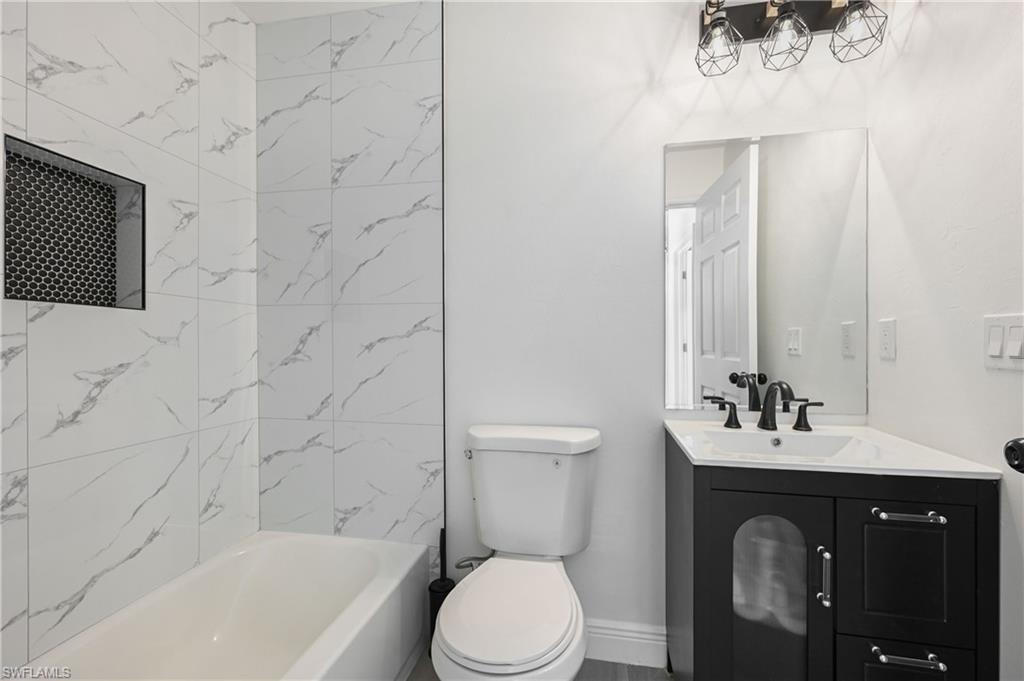 4448 18th Avenue Southwest Naples, FL 34116 - Photo 35 of 40 a bathroom with a sink vanity mirror and toilet